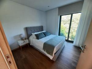 a bedroom with a bed and a large window at Casas Peralta - Outeiro in Arouca +93 photos