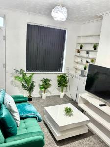 a living room with a green couch and a tv at Premium Cozzy Corner in Leicester +16 photos