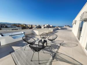 three chairs and a table on a balcony at Luxury Penthouse with Private Jacuzzi & Sea View in Durrës