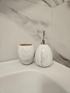 two white vases sitting on top of a sink at Luxury Penthouse with Private Jacuzzi & Sea View in Durrës +26 photos