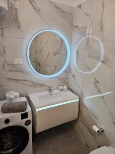 a bathroom with a sink and two round mirrors at Luxury Penthouse with Private Jacuzzi & Sea View in Durrës