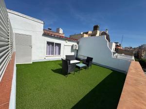a patio with green grass and chairs on a building at MN9 Tarraco in Tarragona