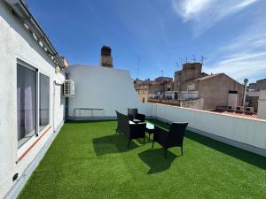 a balcony with green grass and chairs on a building at MN9 Tarraco in Tarragona