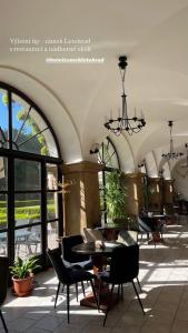 a lobby with tables and chairs and a chandelier at Hotel Zámek Letohrad in Letohrad +22 photos