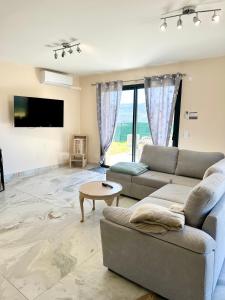 un soggiorno con un divano e un tavolo di LA Conciergerie 05 Villa Kylsha Rosans WiFi Terrasse Confort a Rosans