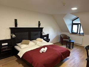 a bedroom with a large bed with slippers on it at Hotel Zámek Letohrad in Letohrad