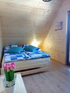 シフィエンタ・カタジナにあるDomki Bursztynの青い枕とピンクの花が飾られたベッドのある寝室