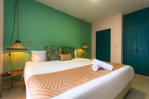 a bedroom with a large bed with two towels on it at Del Trópico Hotel By GyC Hotels in Sopetrán +27 photos