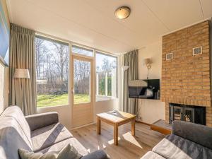a living room with a couch and a fireplace at Cozy holiday home with hot tub on Texel in Den Burg