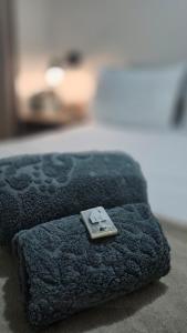 a blue ottoman with a remote control on it at Quarto exclusivo, próximo a Dutra e Vale Sul Shopping em SJCampos-SP in São José dos Campos