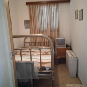 a bedroom with a bunk bed and a television at Ikarian Family Cottage, Ikaria Droutsoulas in Akamatra