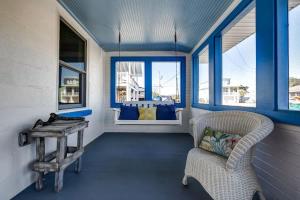 a room with a chair and a table and windows at Turtle Time- Charming 3BR Getaway Near Kure Beach in Kure Beach