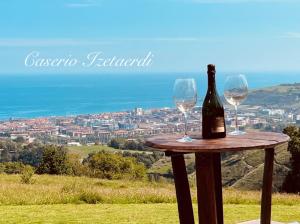 a bottle of wine and two glasses on a table at Izetaerdi - Casa con encanto y vistas únicas in Zarautz +40 photos