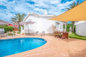 una villa con piscina y una casa en Villa Ginevra, en Son Bou