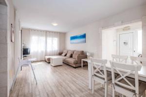 Una sala de estar con un sofá, una mesa y sillas. en Villa Ginevra, en Son Bou