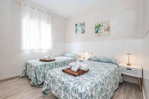 1 dormitorio con 2 camas con sábanas verdes y blancas en Villa Ginevra, en Son Bou 16 fotos más