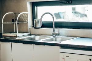 une cuisine avec un évier et une fenêtre dans l'établissement Varkiza Luxury Escape, à Vari 26 autres photos