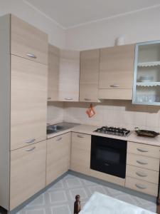 a kitchen with white cabinets and a black oven at Casa Martina in Torre San Giovanni Ugento +7 photos