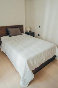 - une chambre avec un grand lit et une couverture blanche dans l'établissement Varkiza Luxury Escape, à Vari