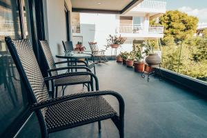 d'une terrasse avec des chaises et des tables sur un balcon. dans l'établissement Varkiza Luxury Escape, à Vari