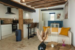 a living room with a couch and a kitchen at Le 7 BIS Loches in Loches