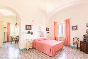 a bedroom with a pink bed and a table at Villa Ginestra by Elite Villas in Capri