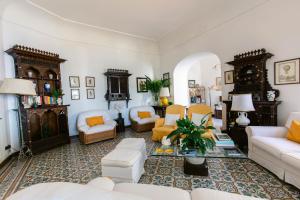 a living room with white furniture and yellow accents at Villa Ginestra by Elite Villas in Capri