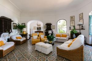 a living room with white furniture and yellow accents at Villa Ginestra by Elite Villas in Capri