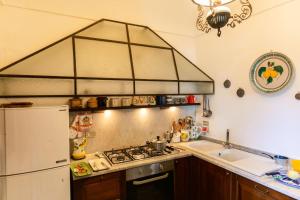 a kitchen with a stove top oven next to a sink at Villa Ginestra by Elite Villas in Capri +39 photos