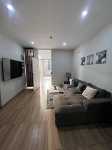 a living room with a couch and a flat screen tv at Apartamento Miraflores country club in Piura