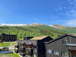 an apartment building with mountains in the background at Helgatunlia - Leilighet 1 in Vossevangen