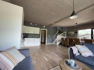 a living room with a couch and a table and a kitchen at Helgatunlia - Leilighet 1 in Vossevangen