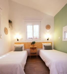 2 camas en una habitación con paredes verdes y blancas en La Casita Andaluz Marbella 10min Beach Walk, en Marbella