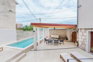 a patio with a table and chairs and a swimming pool at Villa Marisan in Bribir