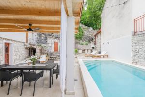 an outdoor patio with a table and a swimming pool at Villa Marisan in Bribir +20 photos