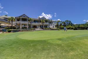 a man standing on a green in front of a house at Shops Restaurants Close King Queen Double Beach Gear and Bike Rentals Included in Hilton Head Island
