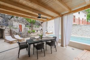 a patio with a table and chairs and a pool at Villa Marisan in Bribir