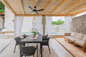a patio with a table and chairs and a ceiling fan at Villa Marisan in Bribir