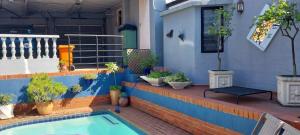 a swimming pool with potted plants next to a house at Studio at 142 in Durban