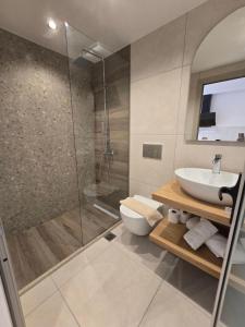 un bagno con doccia, WC e lavandino di White Pebble a Città di Skiathos Altre 40 foto