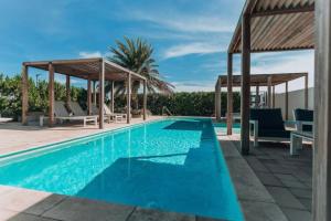 una piscina con sillas y un cenador en Exclusive NEW luxury townhouse with pool in PALM BEACH, en Palm-Eagle Beach