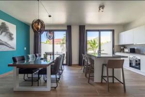 Una cocina y un comedor con mesa y sillas. en Exclusive NEW luxury townhouse with pool in PALM BEACH, en Palm-Eagle Beach