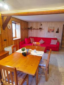 a living room with a table and a red couch at Chalet Torretta in Torgnon