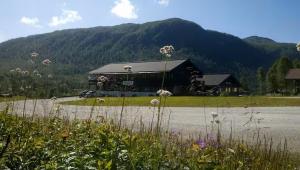 a large black building with a mountain in the background at Helgatunlia - Leilighet 2 in Vossevangen
