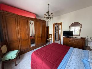 a bedroom with a red bed and a television in it at Casa Vacanze Anita in Carbonia