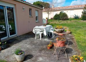Un patio con mesa y sillas y flores. en Maison au calme proche Albi, en Lescure-dʼAlbigeois