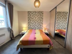 1 dormitorio con cama y espejo. en Maison au calme proche Albi, en Lescure-dʼAlbigeois