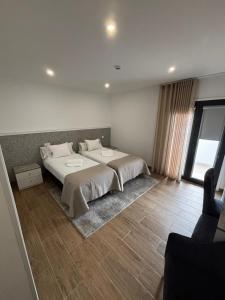 ein Schlafzimmer mit einem großen Bett und einem großen Fenster in der Unterkunft Solar de São Pedro in Monção