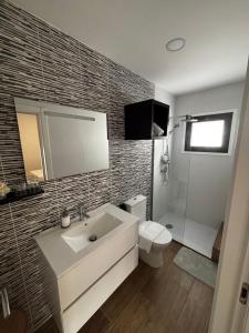 ein Badezimmer mit einem weißen Waschbecken und einer Toilette in der Unterkunft Solar de São Pedro in Monção + 35 Fotos