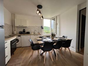 a kitchen and dining room with a table and chairs at Gîte Cosy - 90m2 - T4 - Climatisé - Tout équipé in Retournac
